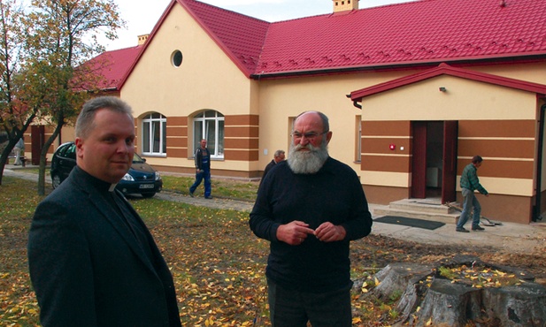 Prace remontowe wciąż trwają. Przed odnowionym ośrodkiem ks. Robert Kowalski  i Wojciech Dąbrowski