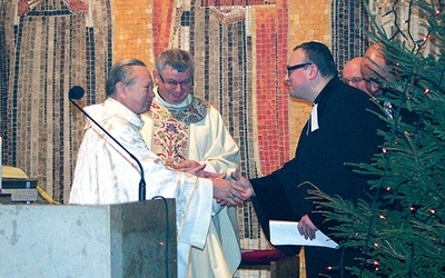  Bp Gerard Kusz i ks. Krzysztof Kłusek, proboszcz gliwickiej parafii ewangelicko-metodystycznej, przekazują sobie znak pokoju