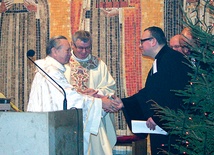  Bp Gerard Kusz i ks. Krzysztof Kłusek, proboszcz gliwickiej parafii ewangelicko-metodystycznej, przekazują sobie znak pokoju