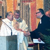  Bp Gerard Kusz i ks. Krzysztof Kłusek, proboszcz gliwickiej parafii ewangelicko-metodystycznej, przekazują sobie znak pokoju