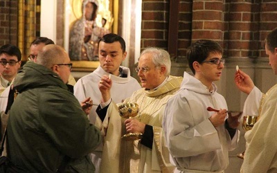 Abp Henryk Hoser podczas udzielania Komunii św. 