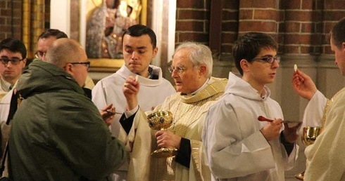 Abp Henryk Hoser podczas udzielania Komunii św. 