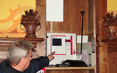 Proboszcz ks. Zygmunt Gil pokazuje, jak działa system przeciwpożarowy w sandomierskiej katedrze