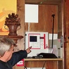 Proboszcz ks. Zygmunt Gil pokazuje, jak działa system przeciwpożarowy w sandomierskiej katedrze