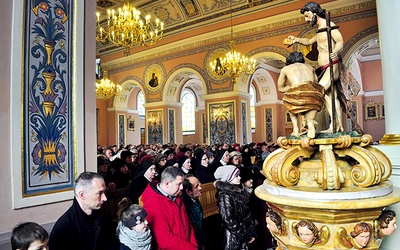  Wierni w kościele Trójcy Świętej w Mławie modlą się przy zabytkowej, neobarokowej chrzcielnicy z XVIII–XIX wieku