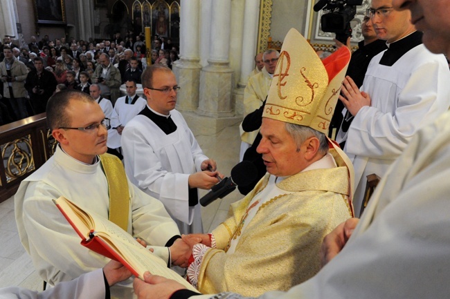 Dłonie święconego kapłana w dłoniach biskupa - to symbol przyrzeczenia posłuszeństwa