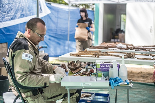 Medyk sądowy dr Szleszkowski w przenośnym laboratorium skrupulatnie opisuje  wszystkie szczątki  
