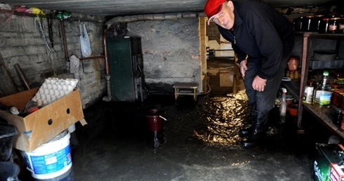 Henryk Zając w zalanej przez wodę piwnicy swojego domu