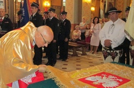 Ks. kustosz Tadeusz Juchas pochyla się przed nowym sztandarem OSP Ludźmierz