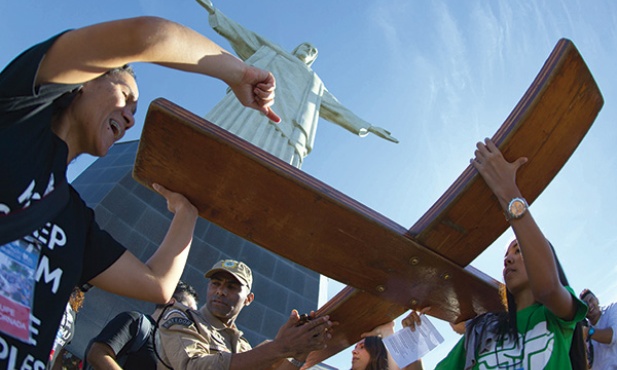  12.07.2013. Brazylia. Rio de janeiro. Młodzi niosący krzyż Światowych Dni Młodzieży pod słynną statuą Chrystusa Odkupiciela na górze Corcovado. Od 22 do 28 lipca w Rio odbędą się Światowe Dni Młodzieży pod przewodnictwem papieża Franciszka  