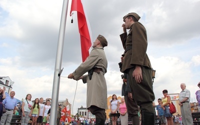 Flagę na maszt wciągają członkowie Muzealnej Grupy Rekonstrukcji Historycznej II Batalionu 18 Pułku Piechoty