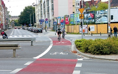  Pas rowerowy na jezdni – jeden cyklista jedzie prawidłowo, zgodnie z namalowaną strzałką, drugi – pod prąd 