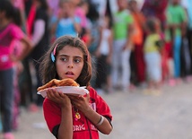 3.09.2013. Irak. Ebril. Dziewczynka z obozu Quru Gusik dla uchodźców z Syrii niesie jedzenie dla swojej rodziny. Według ONZ liczba osób, które opuściły swoje domy z powodu konfliktu, wzrosła do 6,25 miliona.  To największa grupa uchodźców na świecie. Około 168 tys. schroniło się w Iraku. 
