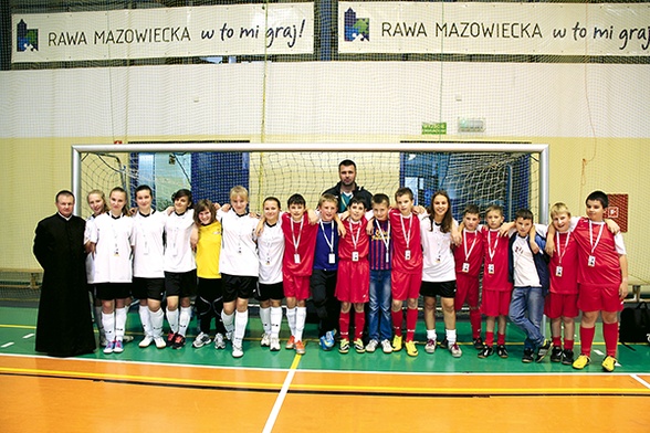 Piłkarskie drużyny dziewcząt i chłopców z Regnowa wraz z trenerem Robertem Stankiewiczem i swoim proboszczem ks. Dariuszem Karpińskim