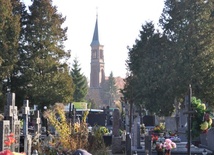 Widok z cmentarza na wieżę parafialnego kościoła