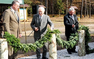  Otwierając ścieżkę, toporkami przecięto symboliczną przegrodę sporządzoną z leśnego igliwia. Pierwszy z lewej Tomasz Sot, dyrektor Regionalnej Dyrekcji Lasów Państwowych w Radomiu 