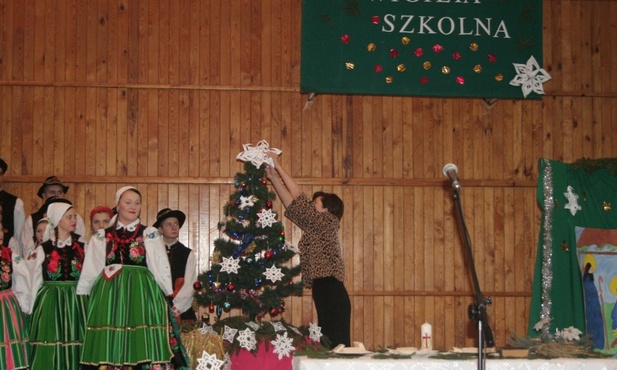 Dyrektor szkoły Maria Laska zawiesza gwiazdę na choince w czasie szkolnego spotkania wigilijnego