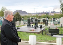 Abp Wiktor Skworc  na cmentarzu w Jenakijewie w Zagłębiu Donbas.  Tam prawdopodobnie pochowane są ofiary tragedii górnośląskiej. W tle huta, jeden z zakładów, w którym pracowali  wywiezieni