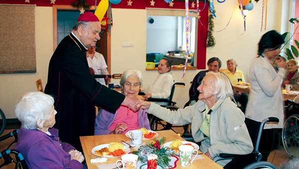 Bp Tadeusz Rakoczy wita się z mieszkańcami domu 