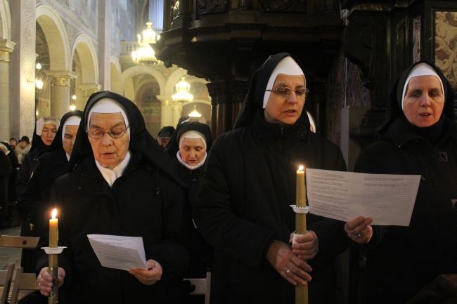 Moment odnowienia ślubów zakonnych, przy zapalonych gromnicach.