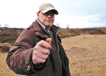 Archeolog Paweł Wiktorowicz z kawałkiem krzemiennego noża na miejscu wykopalisk w Lubomi