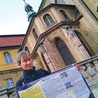  Emil Mendyk pokazuje tablicę informacyjną, która stanie na początku szlaku w Międzygórzu obok oddziału PTTK. Z tyłu kłodzka bazylika Wniebowzięcia NMP, w której znajduje się kaplica św. Jakuba