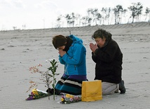11.03.2014. Japonia. Kunie Konno i jej matka Kazue na plaży w Sendai modlą się za ofiary trzęsienia ziemi i tsunami, które nawiedziły Japonię 11 marca 2011 r. Zginęło wówczas 15 884 ludzi. 2636 osób  nadal uważa się za zaginione.