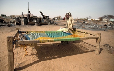  6.04.2014. Sudan. Dziewczyna siedzi na łóżku obok zgliszcz swego spalonego domu. Ponad 3 tys. mieszkańców Darfuru musiało opuścić swoje domy 22 marca br. po ataku zbrojnej grupy