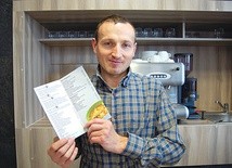 Jeden z pracowników zaprasza do skorzystania z usług punktu gastronomicznego