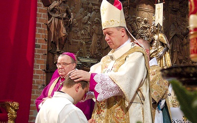 W czasie udzielania święceń biskup nakłada ręce na głowę kandydata  