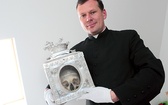 Ks. Marek Wojnarowski pokazuje czaszkę towarzyszki św. Urszuli. Relikwiarze będzie można oglądać w ramach podziemnej wystawy