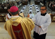 Bp Henryk Tomasik modli się za święconych diakonów
