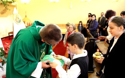 Proboszcz ks. Konrad Świstak przyjmuje dary przyniesione przez dzieci