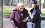 Policjantka ostrzega kobietę przed oszustami