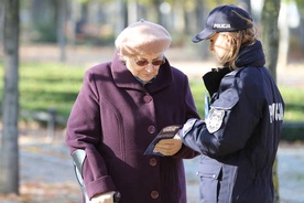 Policjantka ostrzega kobietę przed oszustami