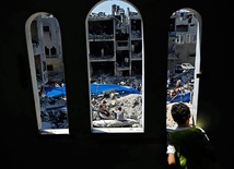  21.08.2014, strefa gazy. Palestyńska młodzież na gruzach domów zniszczonych przez izraelskie odrzutowce w mieście Rafah, w południowej Strefie Gazy.