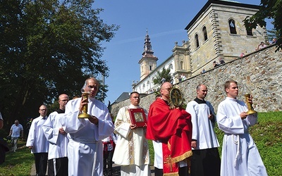 Procesja z relikwiami Drzewa Krzyża Świętego. W tle odbudowana  wieża kościelna