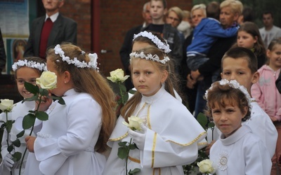 Dzieci pierwszokomunijne witały obraz kwiatami