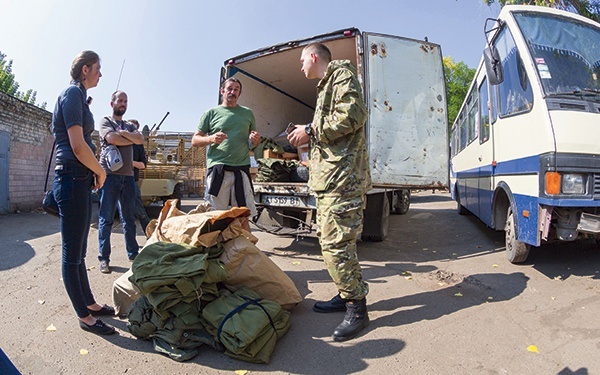 Przemysław  Miśkiewicz (trzeci od lewej)przekazuje dresy i pałatki przedstawicielowi  Batalionu Ługańsk