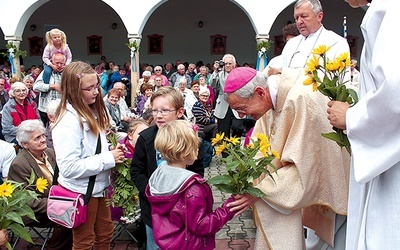 Biskup L. Schick przyjmuje od dzieci i młodzieży kwiaty i dary ołtarza