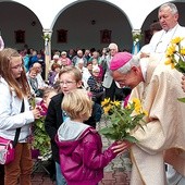 Biskup L. Schick przyjmuje od dzieci i młodzieży kwiaty i dary ołtarza