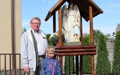 Benedykt Chojnacki z wnukiem Jasiem przy kapliczce, którą wykonali