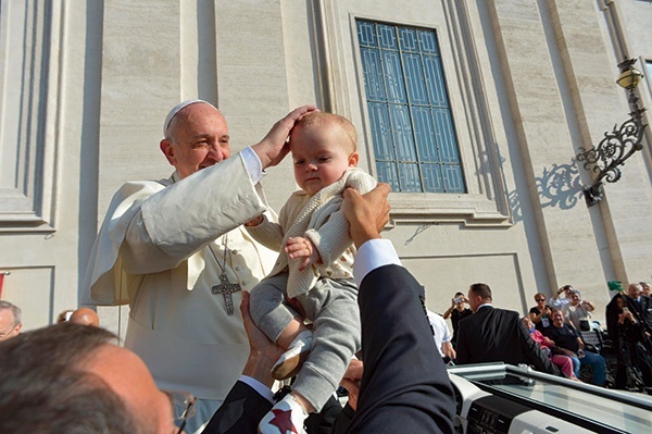  8 października 2014, watykan. Papież Franciszek błogosławi dziecko podane mu przez osobę stojącą w tłumie wiernych w czasie środowej audiencji na placu Świętego Piotra. W Watykanie trwa synod o rodzinie.