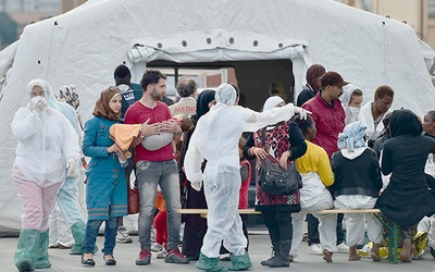 20.10. 2014. Palermo. Włochy. Do portu w Palermo dotarła kolejna grupa imigrantów uratowanych przez straż przybrzeżną. Czerwony Krzyż i katolicka Caritas zorganizowały dla nich pomoc.