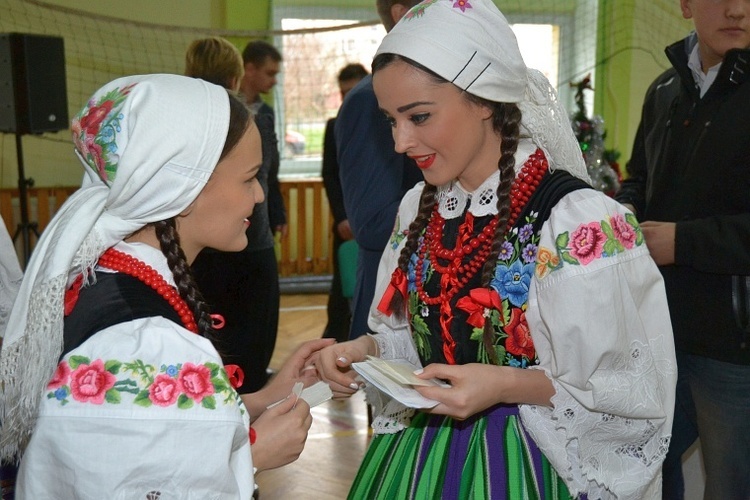 Uczennice szkoły w strojach łowickich dzielą sie opłatkiem