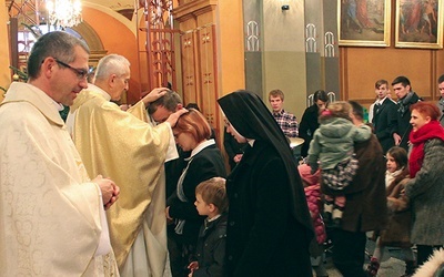 Indywidualne błogosławieństwo rodzin po Eucharystii. Na zdjęciu ks. F. Płonka  modli się nad M. i R. Bielickimi.  Z lewej ks. T. Gorczyński 