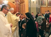 Indywidualne błogosławieństwo rodzin po Eucharystii. Na zdjęciu ks. F. Płonka  modli się nad M. i R. Bielickimi.  Z lewej ks. T. Gorczyński 