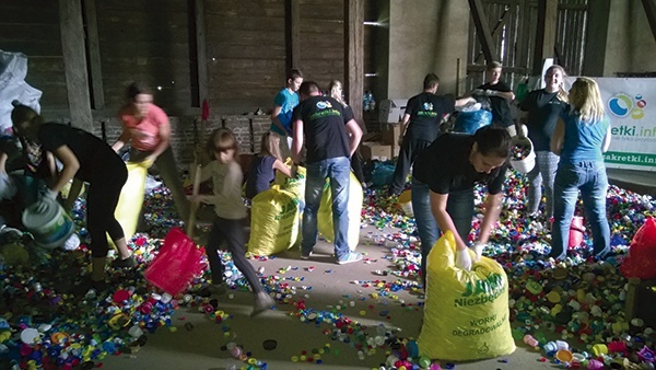 Pakowanie nakrętek w magazynie Fundacji Bez Granic przed przewiezieniem do firmy recyklingowej