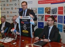 Prezydent Radosław Witkowski prezentuje koszulkę przyjmującego Wojciecha Żalińskiego, którą wylicytował podczas finału WOŚP