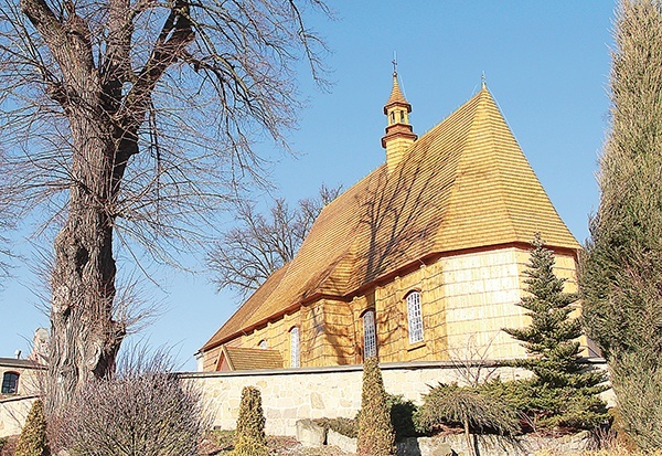 Nowiutki gont na dachu i ścianach jodłowskiej świątyni lśni w świetle słońca 